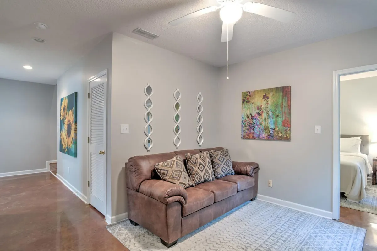 A cozy living area with a comfortable sofa, decorative mirrors, and wall art, designed for group gatherings and conversation. The space feels inviting and contemporary, with thoughtful decor that encourages guests to unwind together.